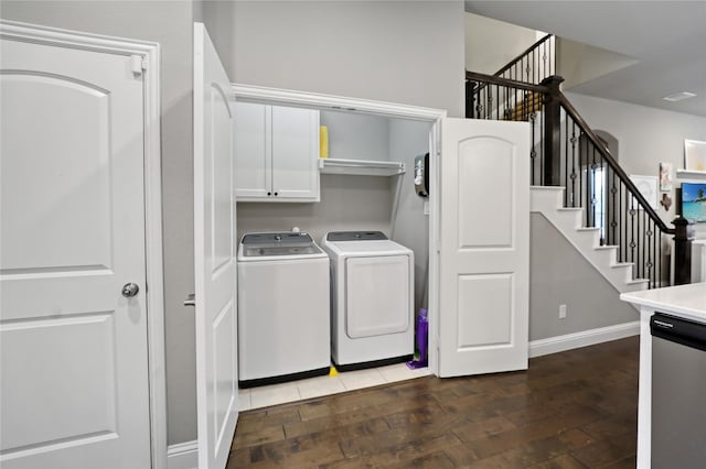 washroom with baseboards, wood finished floors, washer and dryer, and cabinet space