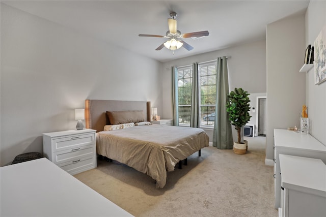 bedroom with light carpet and a ceiling fan