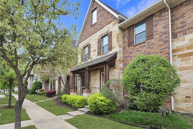 multi unit property featuring brick siding and a front yard