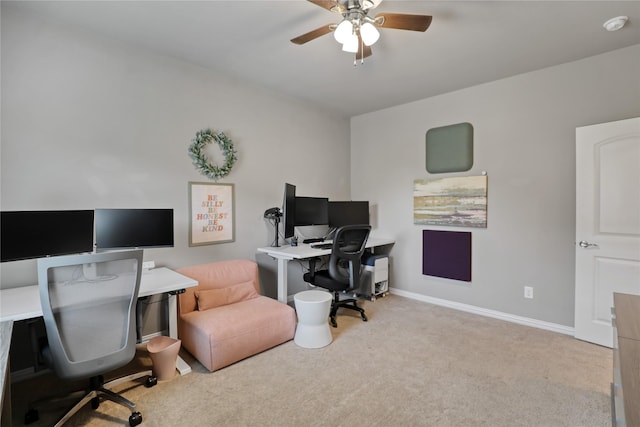 carpeted home office featuring baseboards and ceiling fan