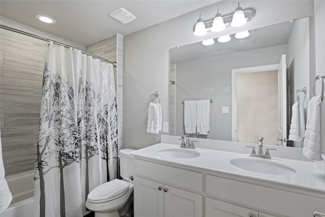 bathroom featuring double vanity, shower / bath combo with shower curtain, toilet, and a sink