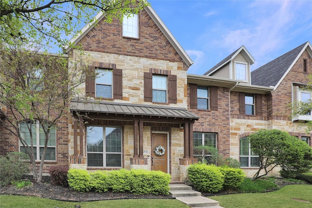 townhome / multi-family property with brick siding and stone siding
