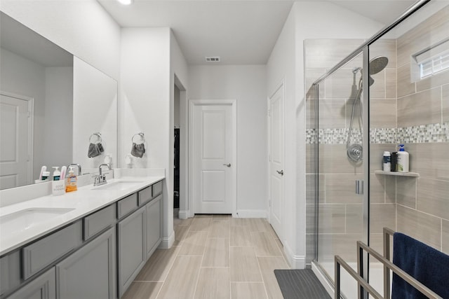 full bathroom featuring a sink, visible vents, double vanity, and a stall shower
