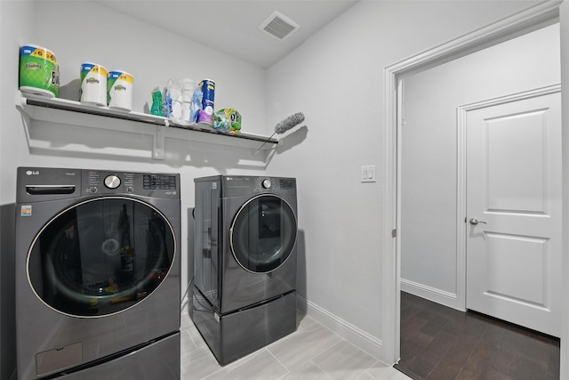 clothes washing area featuring visible vents, baseboards, separate washer and dryer, laundry area, and wood finished floors