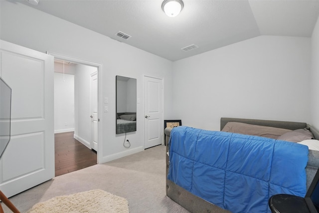 carpeted bedroom with visible vents, baseboards, attic access, and lofted ceiling