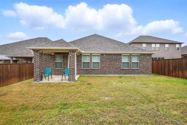 back of house featuring a patio area, brick siding, and a yard