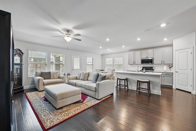 living room with dark wood-type flooring, visible vents, a ceiling fan, and recessed lighting