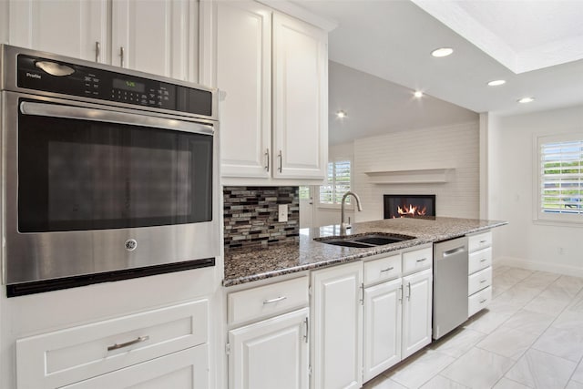 5111 Cimmaron Cir, Parker, TX 75002 - kitchen featuring a sink, appliances with stainless steel finishes, light marble finish floors, a fireplace, and healthy amount of natural light