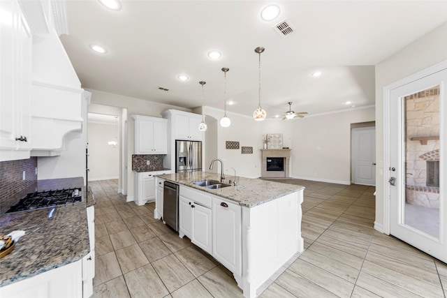 971 Abbott Ln, Allen, TX 75013 - kitchen featuring a glass covered fireplace, a sink, stainless steel appliances, decorative backsplash, and ceiling fan