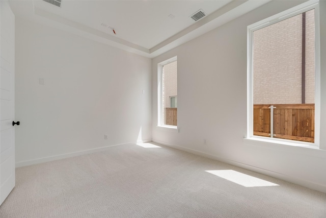 carpeted empty room with visible vents and baseboards
