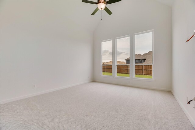 spare room with a healthy amount of sunlight, baseboards, ceiling fan, and light carpet