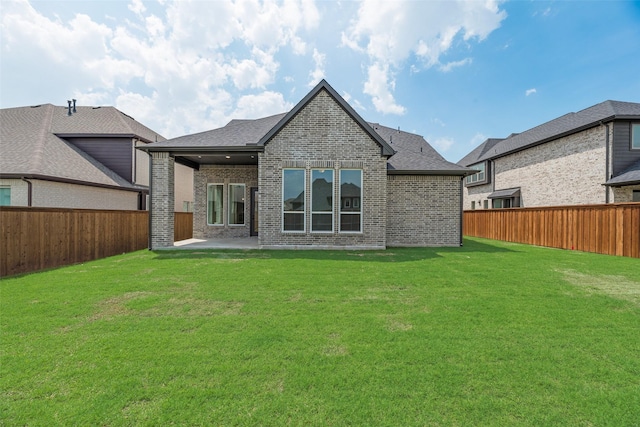 back of property featuring a fenced backyard, a patio area, and brick siding