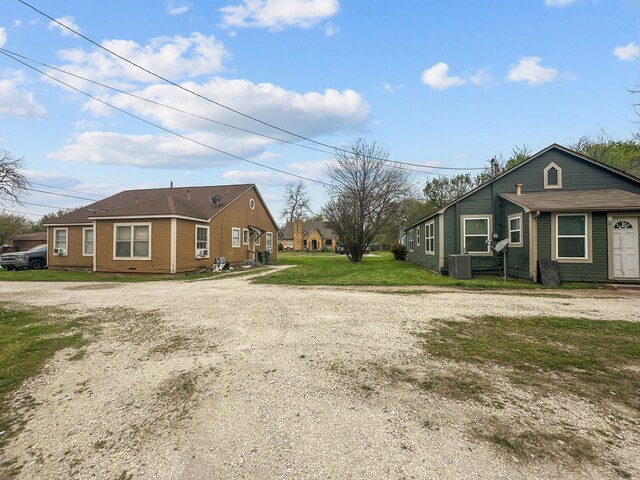 706 N Commerce St, Gainesville, TX 76240 - view of property exterior featuring a yard, central AC, and driveway