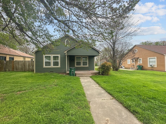 706 N Commerce St, Gainesville, TX 76240 - bungalow-style home with cooling unit, covered porch, fence, and a front lawn