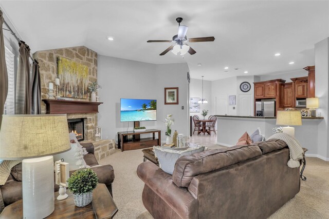 living area featuring a ceiling fan, a fireplace, recessed lighting, vaulted ceiling, and light colored carpet