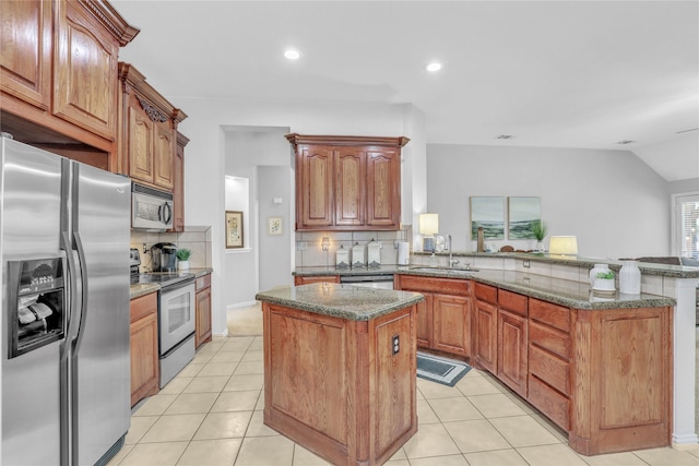 kitchen with tasteful backsplash, a center island, a sink, a peninsula, and stainless steel appliances