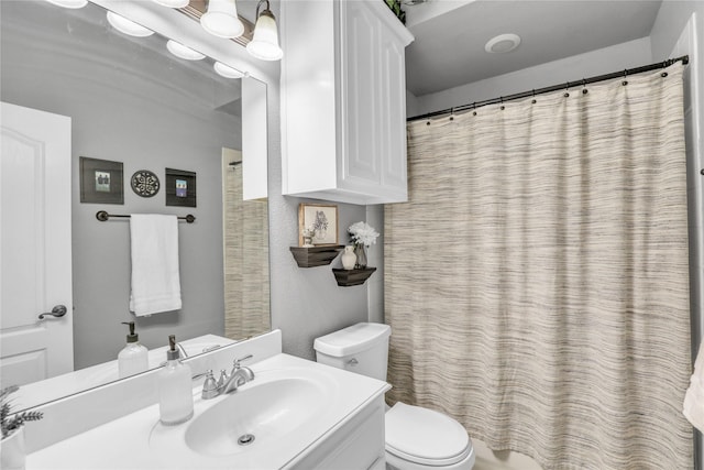 bathroom with a shower with shower curtain, vanity, and toilet