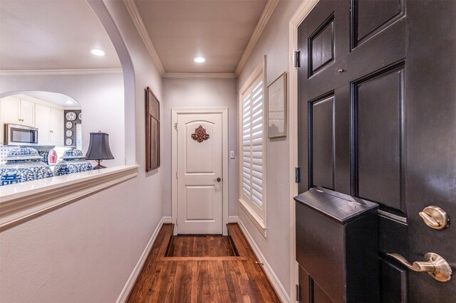 doorway featuring dark wood finished floors, arched walkways, ornamental molding, recessed lighting, and baseboards