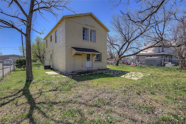 back of property featuring a fenced backyard, central AC, and a lawn