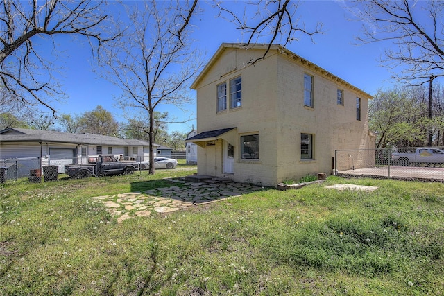 back of property with fence and a lawn