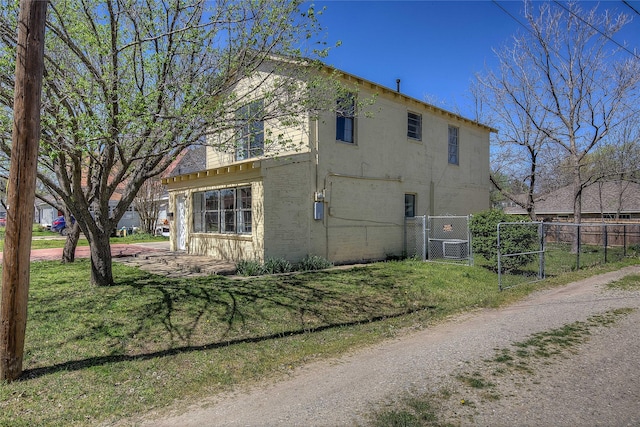 view of property exterior featuring fence and a lawn