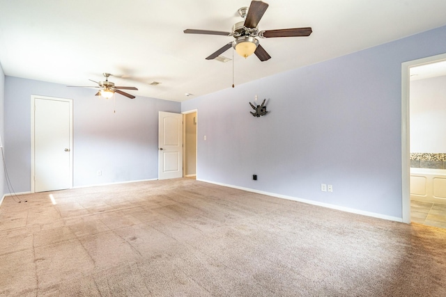 carpeted empty room with baseboards, a ceiling fan, and visible vents
