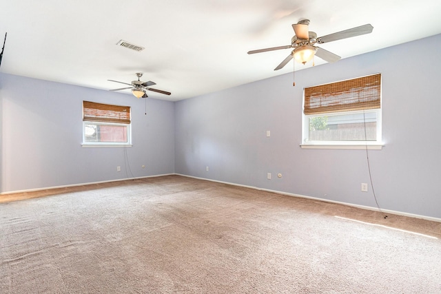 unfurnished room with baseboards, a ceiling fan, visible vents, and carpet floors