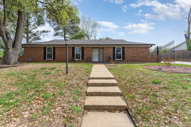 ranch-style house featuring brick siding, a front lawn, and fence