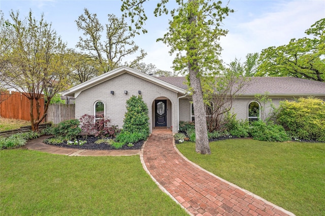ranch-style home with fence, a front lawn, and brick siding
