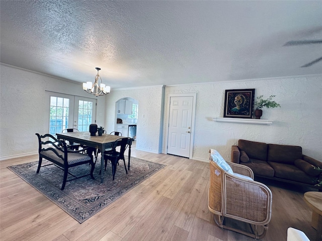 1317 N Mary St, Comanche, TX 76442 - dining area with wood finished floors, a textured ceiling, a chandelier, arched walkways, and a ceiling fan