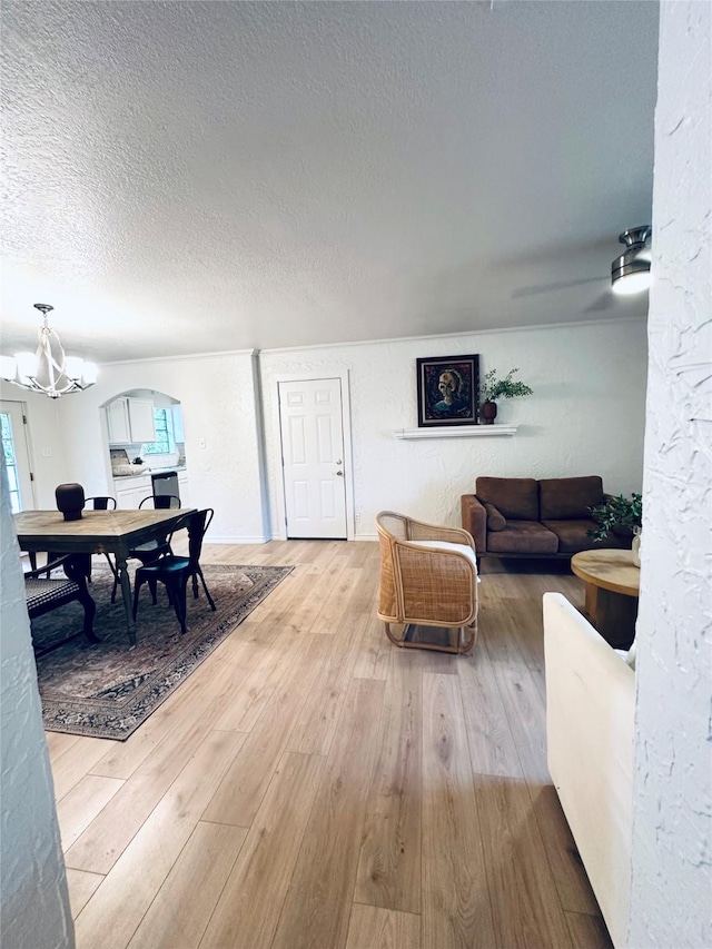 1317 N Mary St, Comanche, TX 76442 - living area with a textured wall, a textured ceiling, hardwood / wood-style flooring, arched walkways, and ornamental molding