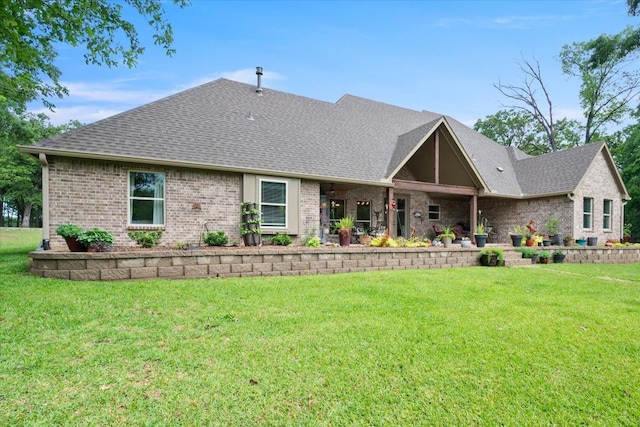 view of front facade featuring brick siding, a front lawn, and a shingled roof