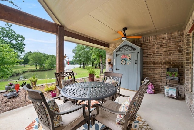 view of patio / terrace featuring outdoor dining space, ceiling fan, and a water view