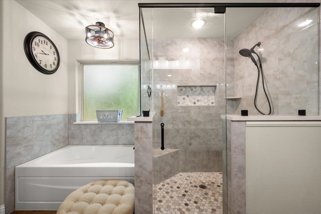 bathroom featuring a bath and a shower stall