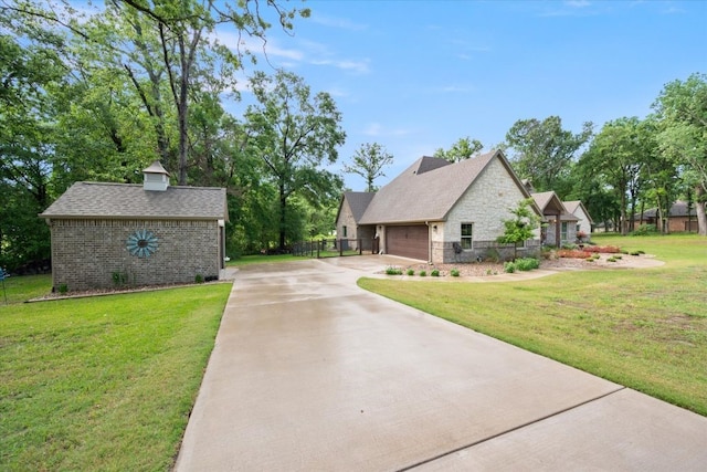 view of front facade with driveway, stone siding, a front yard, fence, and a garage