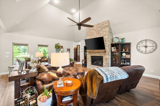 living room with ceiling fan, baseboards, a fireplace, wood finished floors, and high vaulted ceiling