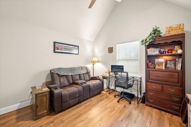 office featuring light wood-type flooring, a ceiling fan, vaulted ceiling, and baseboards