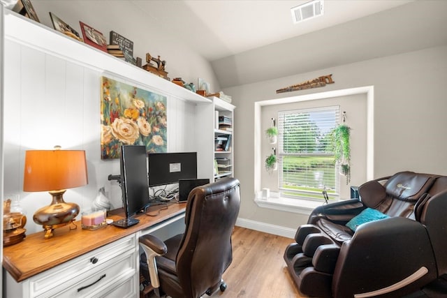 office featuring lofted ceiling, visible vents, baseboards, and light wood-style floors