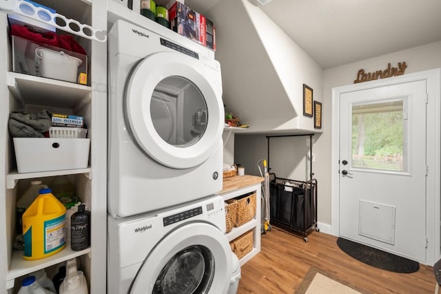 laundry room with baseboards, stacked washing maching and dryer, laundry area, and light wood-style floors