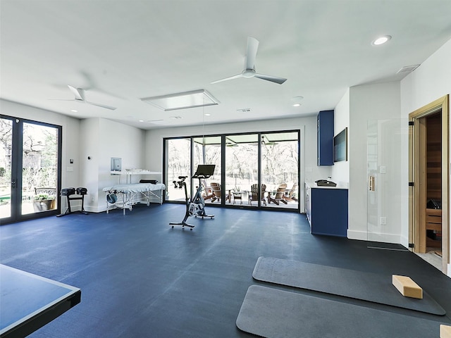 workout area featuring attic access, ceiling fan, baseboards, and plenty of natural light