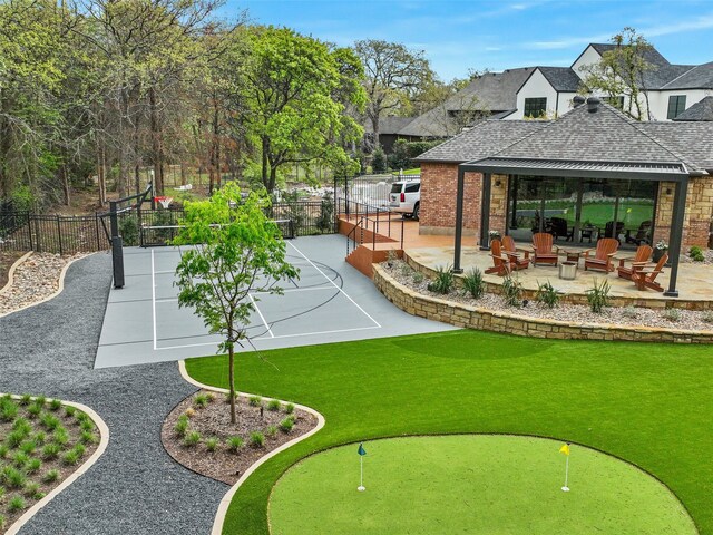 view of property's community featuring a lawn, fence, and a patio