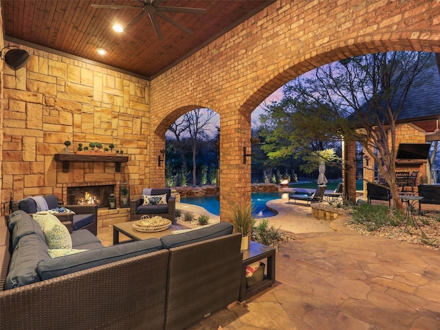 view of patio / terrace featuring an outdoor living space with a fireplace, an outdoor pool, and a ceiling fan