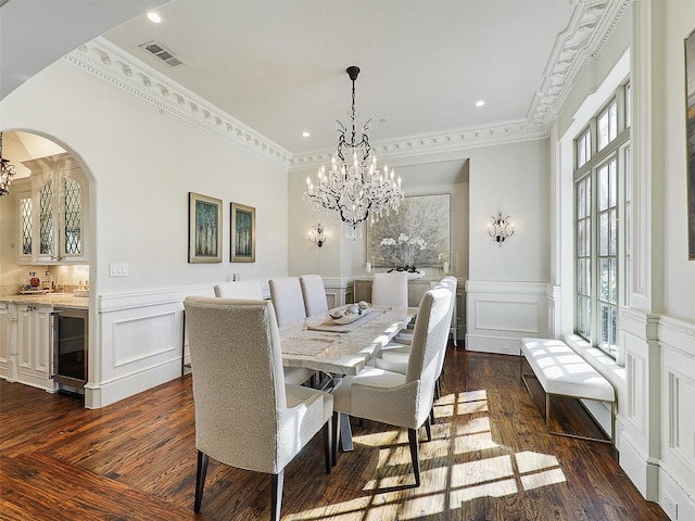 dining space with an inviting chandelier, a decorative wall, and wine cooler