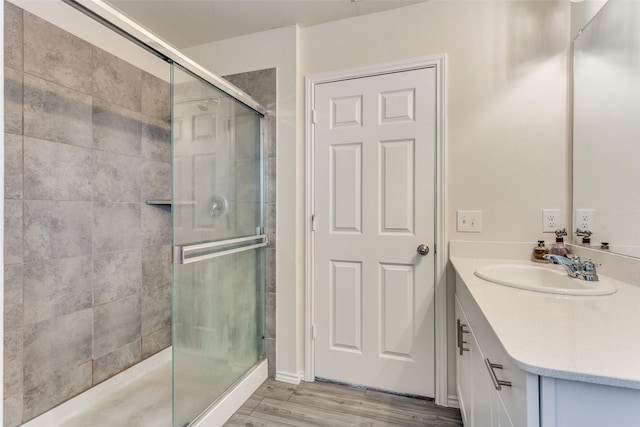 bathroom featuring vanity, wood finished floors, and a stall shower