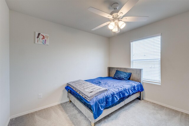 carpeted bedroom with baseboards, multiple windows, and ceiling fan