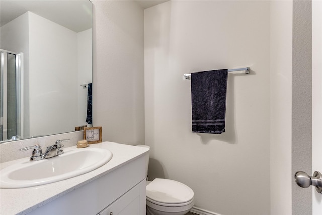 full bathroom with toilet, a shower with shower door, and vanity
