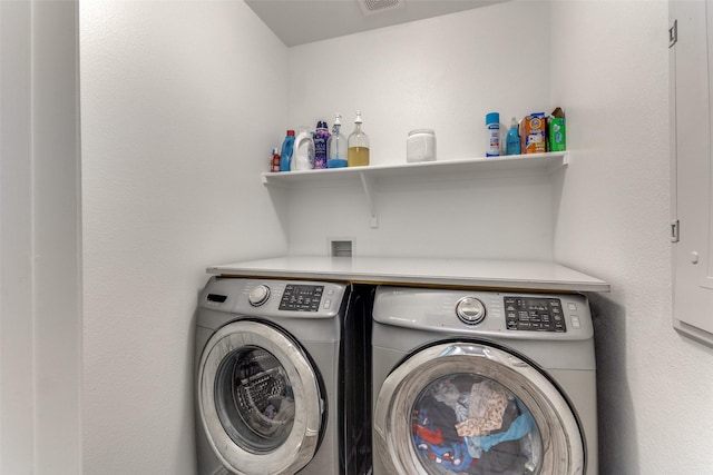 laundry area with laundry area, washing machine and dryer, and visible vents