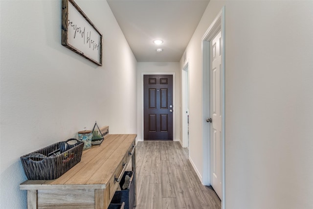 doorway to outside featuring light wood-type flooring and baseboards