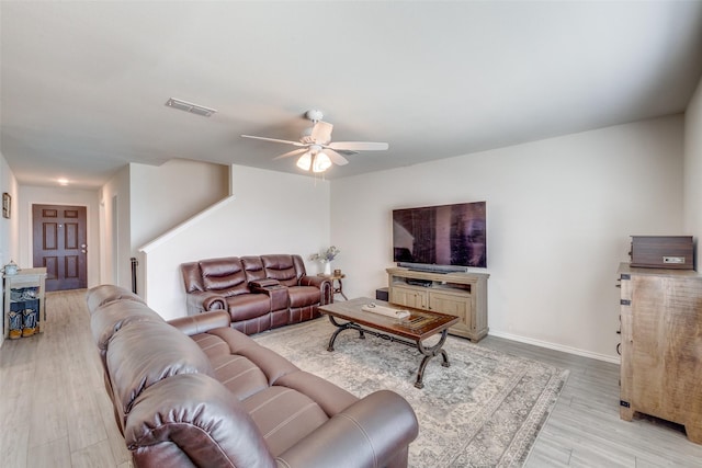 living room with visible vents, light wood-style floors, ceiling fan, and baseboards