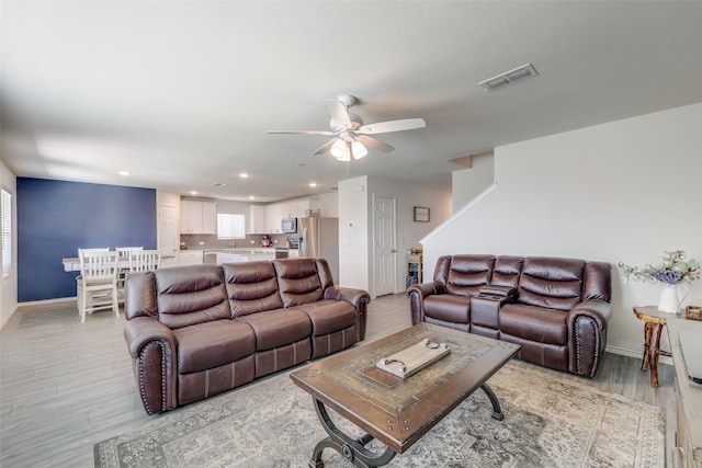 living area with a ceiling fan, baseboards, recessed lighting, light wood-type flooring, and visible vents